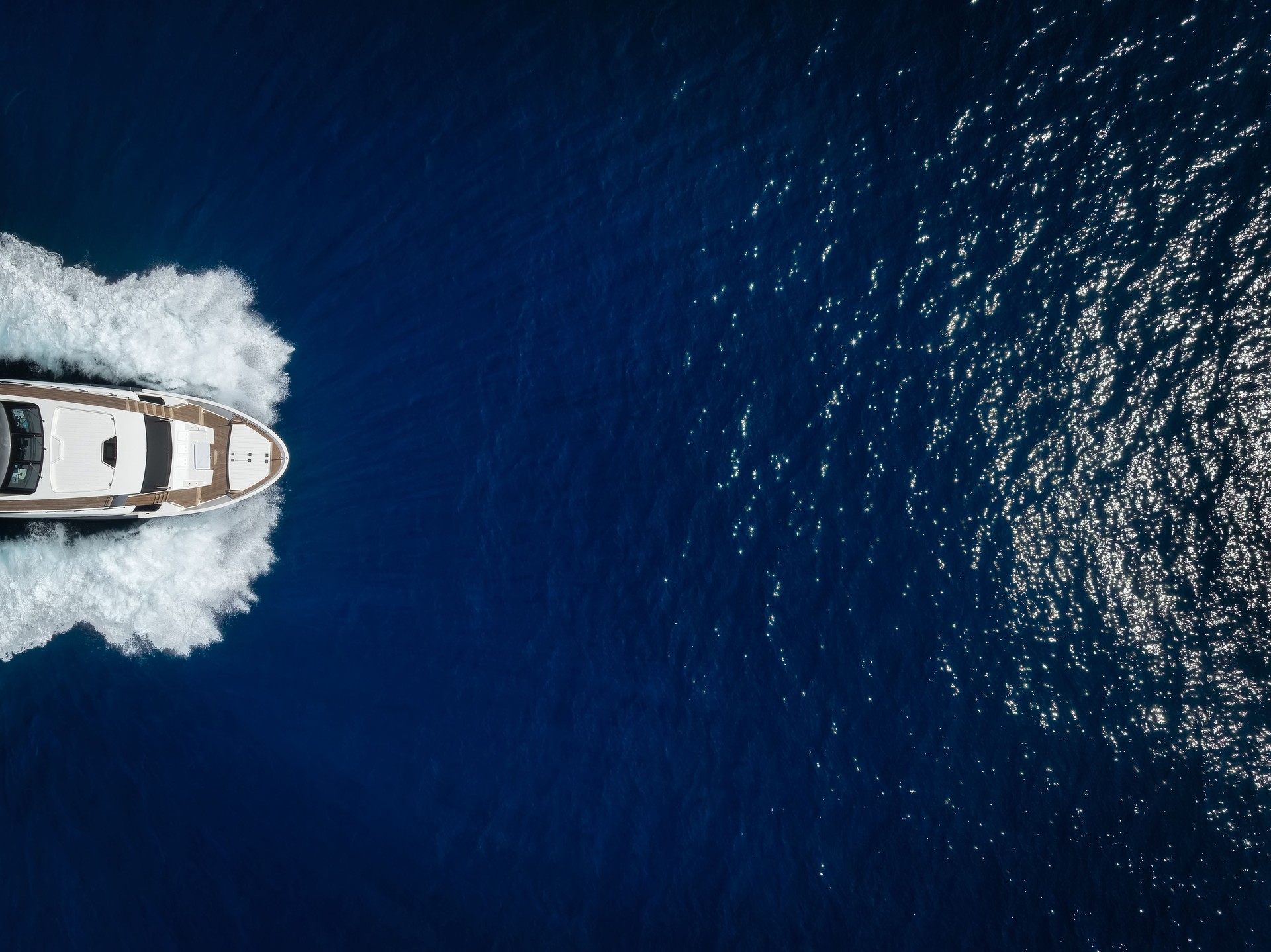 Overhead view of a bow of a luxury yacht sailing with high speed over the ocean