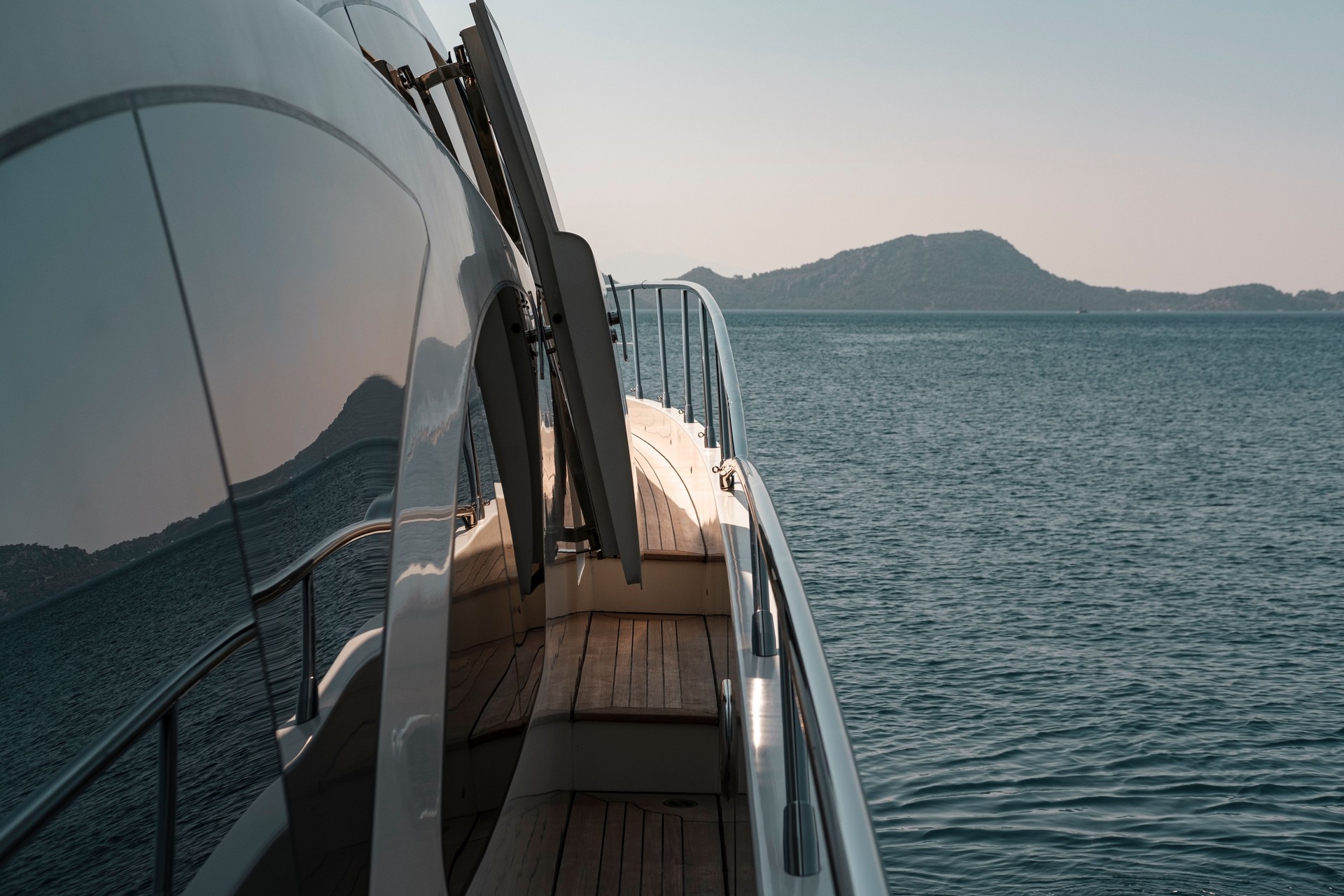 twilight or sunset on board of motor mega yacht luxury holiday, seascape, mountain coastline, calm sea